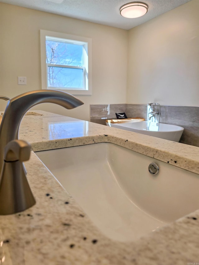 interior details featuring a textured ceiling and a sink