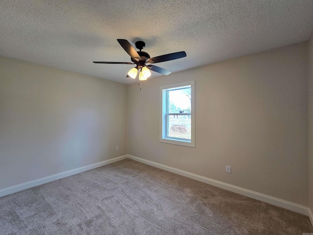 carpeted empty room with a ceiling fan, a textured ceiling, and baseboards