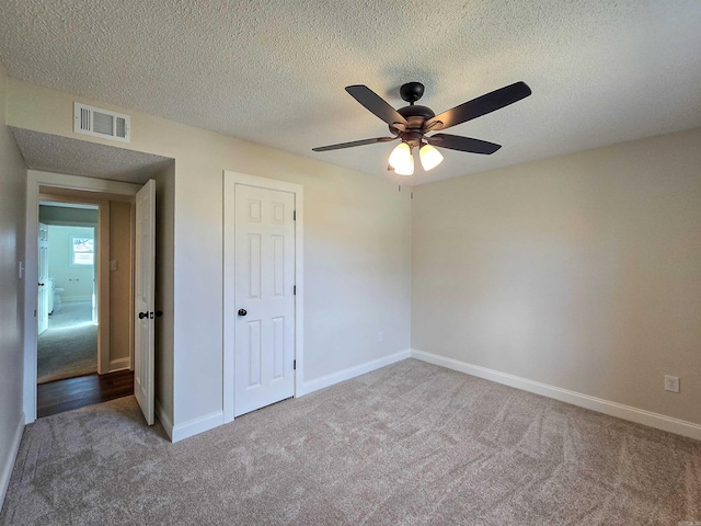 unfurnished bedroom featuring carpet floors, visible vents, baseboards, and a ceiling fan