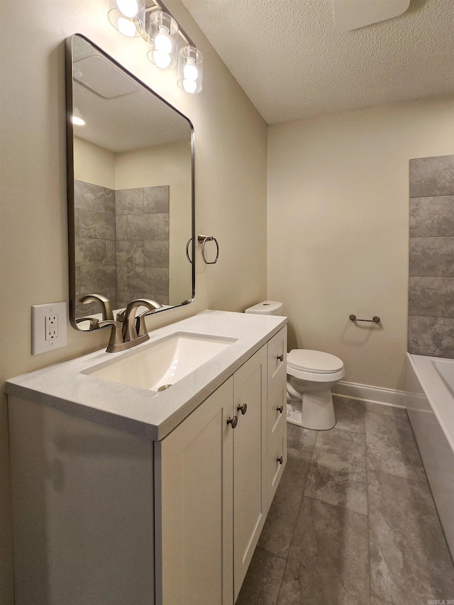 bathroom with a textured ceiling, a tub to relax in, toilet, vanity, and baseboards