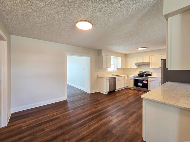 kitchen with dark wood finished floors, stainless steel appliances, white cabinetry, a sink, and baseboards