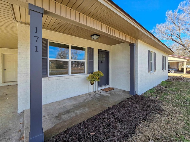 view of exterior entry with brick siding