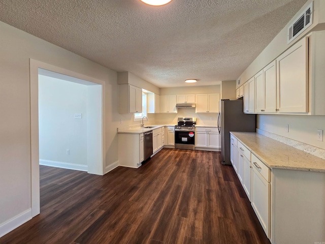 kitchen featuring dark wood-style flooring, visible vents, appliances with stainless steel finishes, a sink, and under cabinet range hood