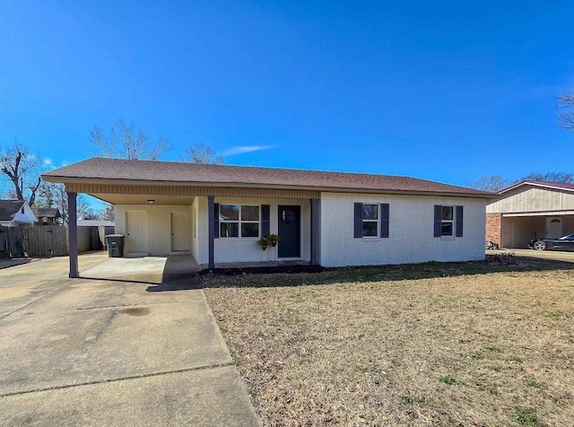 single story home with brick siding, fence, an attached carport, driveway, and a front lawn