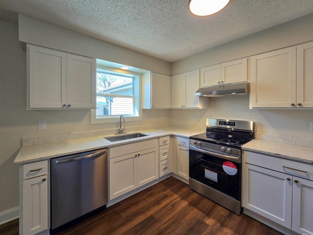 kitchen with appliances with stainless steel finishes, dark wood-type flooring, white cabinetry, a sink, and under cabinet range hood