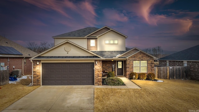 traditional-style house with a garage, driveway, fence, cooling unit, and brick siding