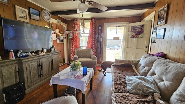 living room with dark wood finished floors, beamed ceiling, and a textured ceiling