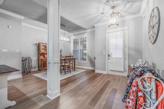 foyer entrance with baseboards, ornamental molding, and wood finished floors