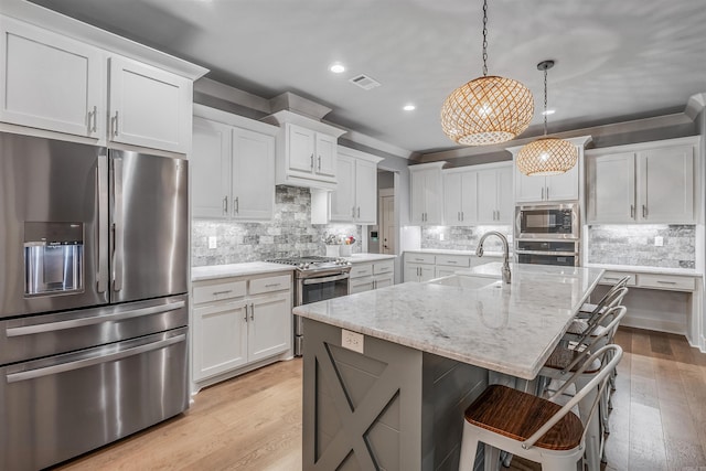 kitchen featuring stainless steel appliances, a sink, visible vents, and white cabinets