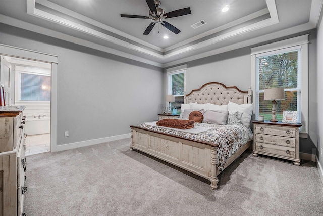 carpeted bedroom featuring visible vents, multiple windows, a tray ceiling, and baseboards