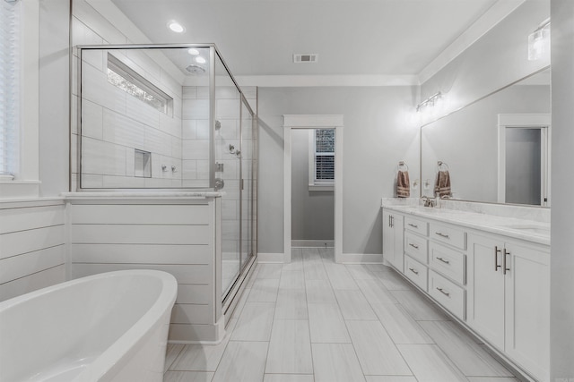 full bathroom featuring double vanity, a stall shower, baseboards, visible vents, and a freestanding tub