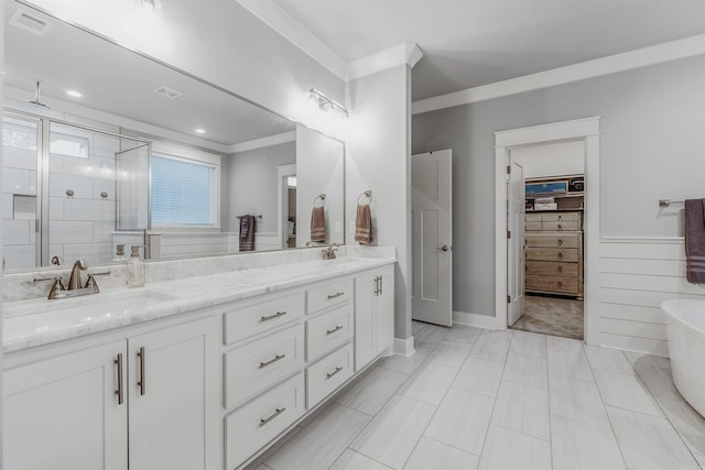 bathroom featuring a freestanding tub, visible vents, a sink, and double vanity