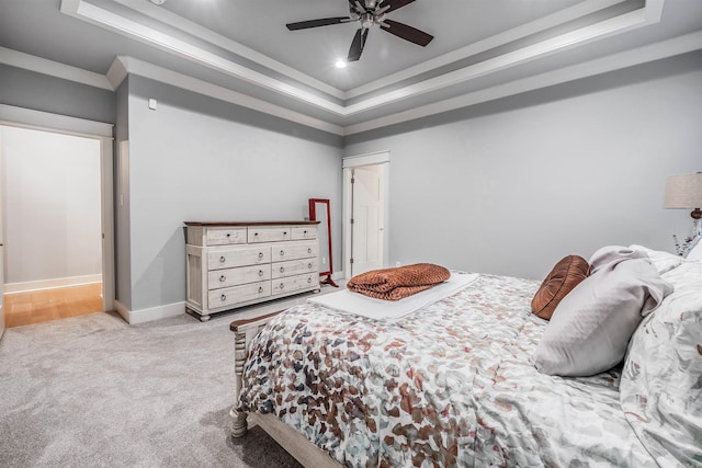 bedroom with carpet, crown molding, a raised ceiling, ceiling fan, and baseboards