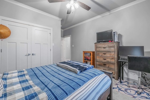 bedroom featuring a ceiling fan, ornamental molding, a closet, and carpet flooring