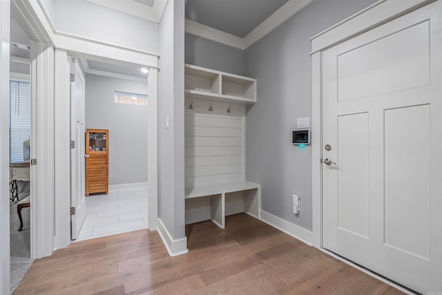 mudroom featuring ornamental molding, baseboards, and wood finished floors