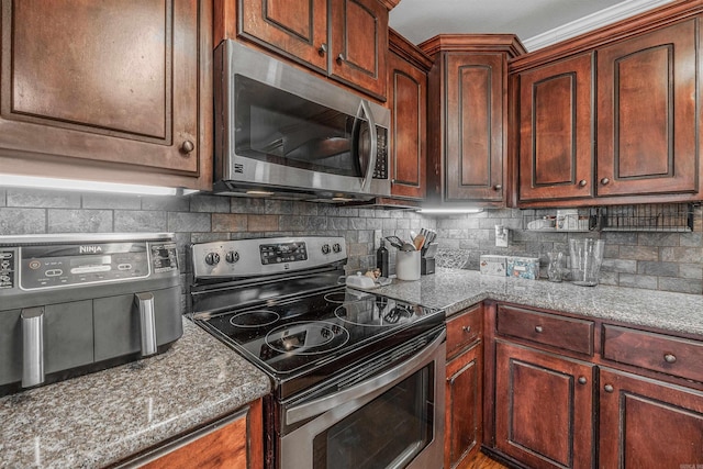 kitchen featuring appliances with stainless steel finishes, decorative backsplash, and light stone countertops