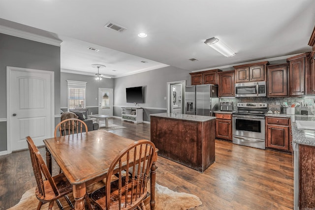 kitchen featuring dark wood-style floors, appliances with stainless steel finishes, and a center island