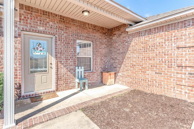 entrance to property featuring brick siding