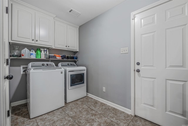 clothes washing area featuring washer and clothes dryer, light tile patterned floors, visible vents, cabinet space, and baseboards