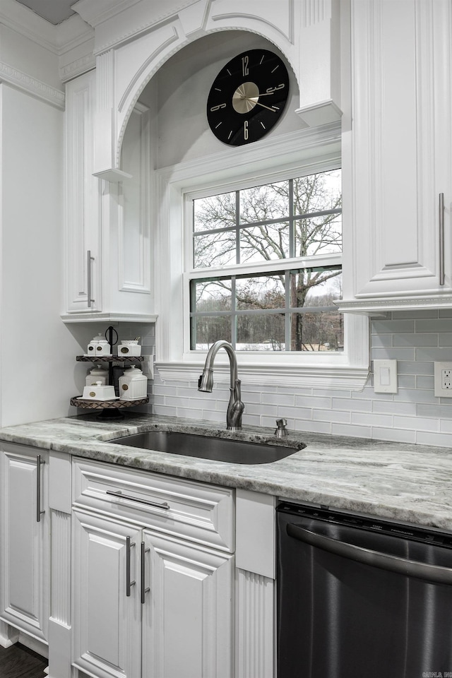 kitchen with dishwasher, light stone counters, backsplash, white cabinetry, and a sink