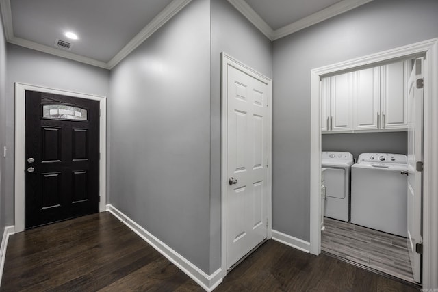 entryway featuring dark wood finished floors, visible vents, crown molding, and separate washer and dryer