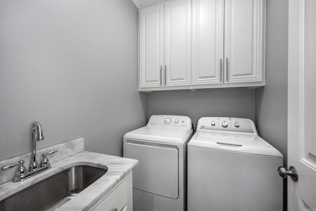 laundry room featuring cabinet space, a sink, and washing machine and clothes dryer