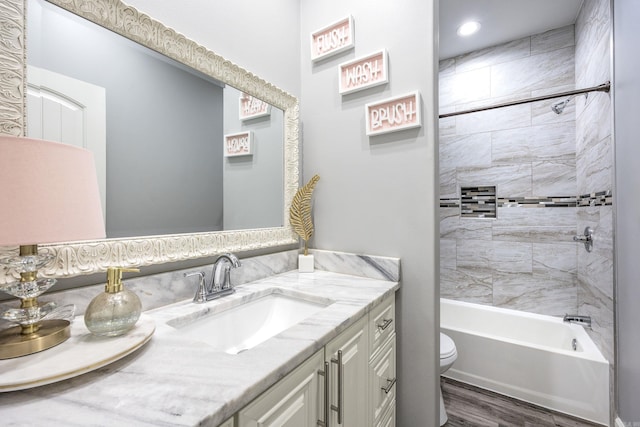 full bath featuring toilet, shower / bathing tub combination, wood finished floors, and vanity