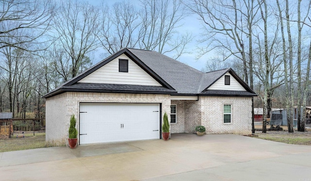 view of front of home with an attached garage, roof with shingles, concrete driveway, and brick siding