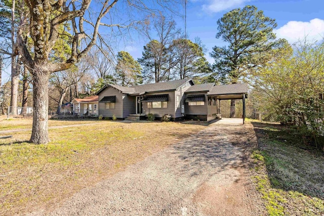 ranch-style home with an attached carport, crawl space, driveway, and a front lawn