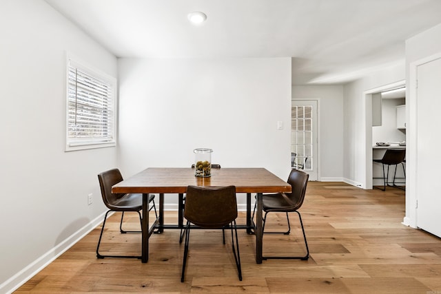 dining room with light wood-type flooring and baseboards