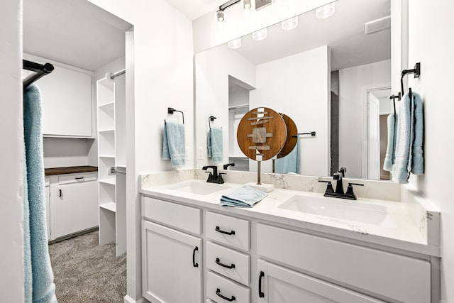 bathroom with visible vents, a sink, and double vanity