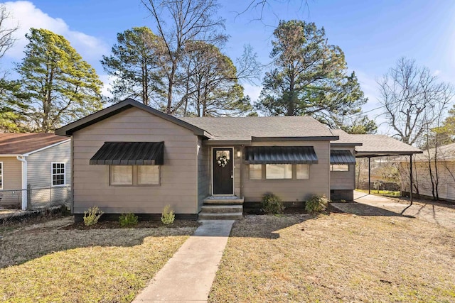 view of front of home with an attached carport, roof with shingles, and fence