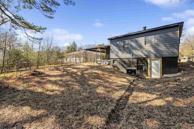 back of house featuring central AC and fence