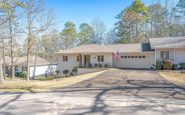 single story home with an attached garage and aphalt driveway