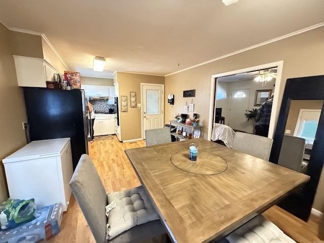 dining area with a ceiling fan, light wood-style flooring, and crown molding