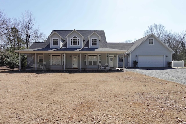 view of front of house with covered porch, gravel driveway, and a garage