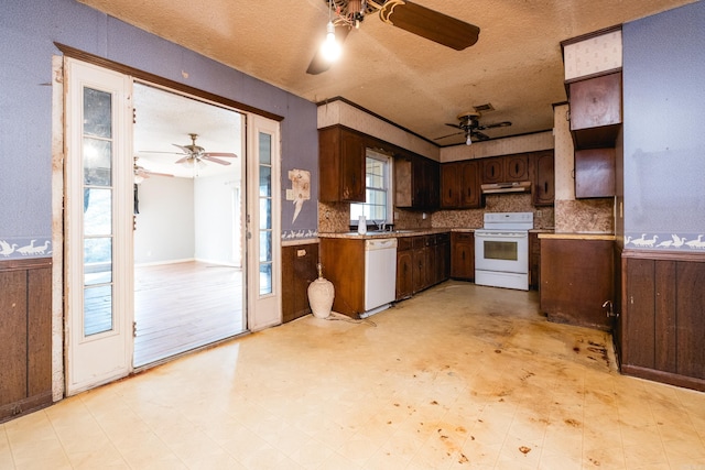 kitchen featuring white appliances, wainscoting, under cabinet range hood, and light floors