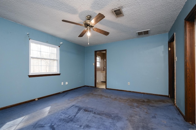 empty room with a textured ceiling, visible vents, and baseboards