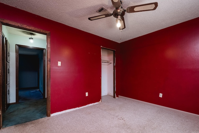 unfurnished bedroom with a textured ceiling, carpet floors, a closet, and baseboards