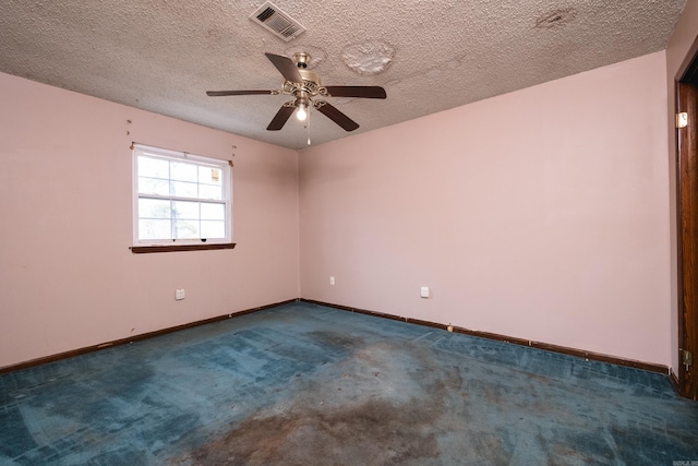 unfurnished room with baseboards, visible vents, dark colored carpet, and a textured ceiling