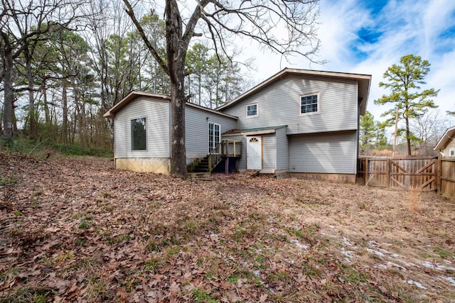 back of house with entry steps and fence