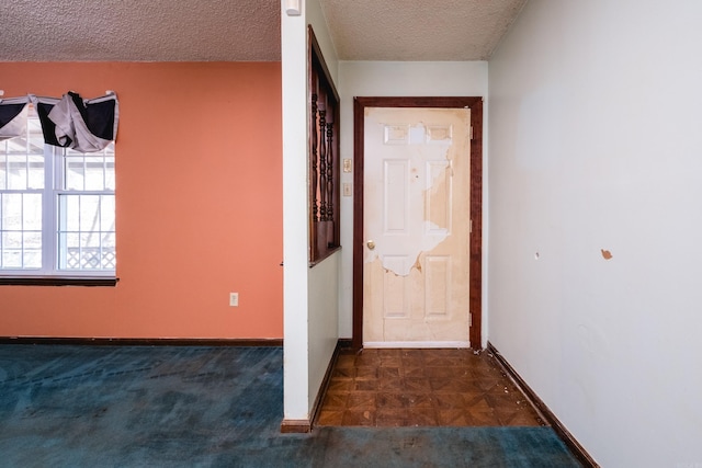 interior space featuring a textured ceiling and baseboards