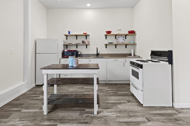 kitchen featuring white appliances, a sink, open shelves, and wood finished floors