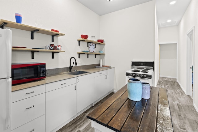 kitchen with white appliances, white cabinets, light wood-style flooring, open shelves, and a sink