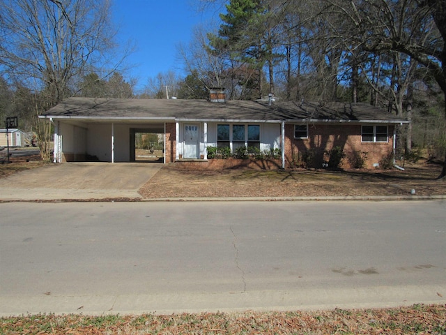 ranch-style home featuring a carport, brick siding, and concrete driveway