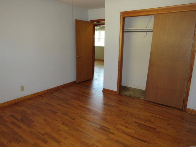 unfurnished bedroom featuring a closet, baseboards, and wood finished floors