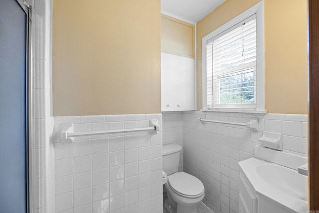 bathroom featuring toilet, wainscoting, and vanity