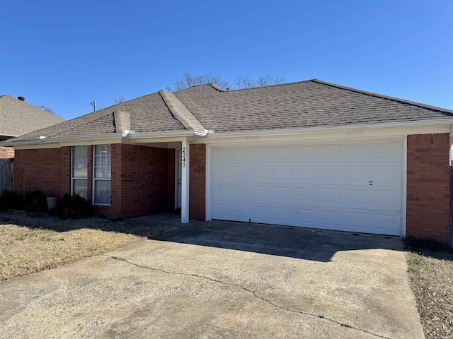 single story home with driveway, a shingled roof, a garage, and brick siding