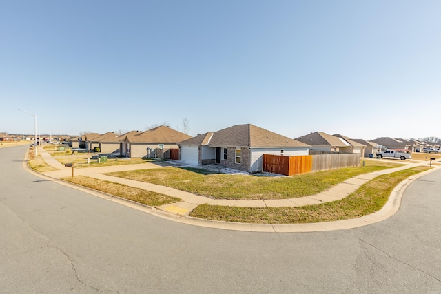 view of front of property featuring stone siding, a residential view, and fence