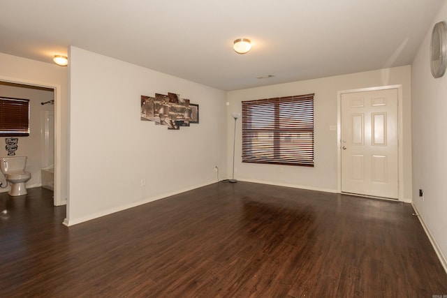 empty room with dark wood-style floors and baseboards